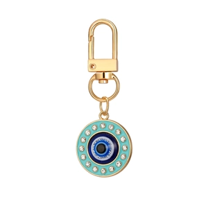 Close-up of golden evil eye keychain with blue enamel and sparkling crystals