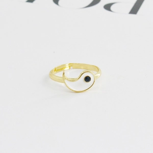 Detail of gold-plated adjustable ring featuring white enamel and black crystal yin yang motif