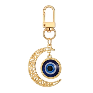 Porte-clés croissant de lune doré avec œil bleu et motif de gravure évidé élégant