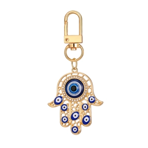 Porte-clés main de Hamsa dorée avec œil bleu maléfique et cristaux scintillants