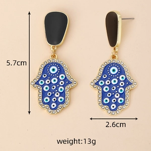 Détail des boucles d'oreilles Main de Fatima avec motifs œil bleu et cristaux