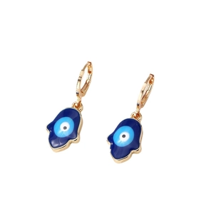 Boucles d'oreilles Main de Fatma dorées avec breloque œil bleu sur fond blanc épuré