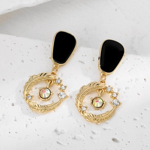 Détail macro de boucles d'oreilles vintage en or avec émail noir et strass étincelants