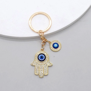 Golden Hamsa Hand and Evil Eye keychain with blue accents and sparkling crystals