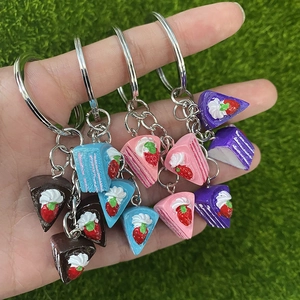 Miniature multi-layer strawberry cake keychains in four colors for DIY craft decoration