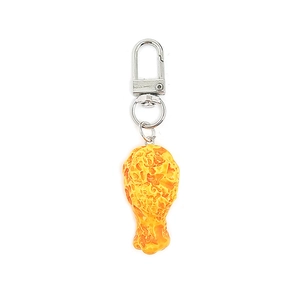 Detail shot of a fried chicken leg keychain featuring realistic resin texture and metal clasp