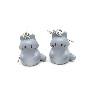 Foto macro de pendientes de gato gris en resina con diseño de dibujos animados en 3D