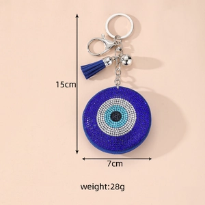 Detailed close-up of Evil Eye bag charm with blue rhinestones, silk tassel and metal bell