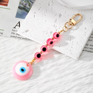 Detailed view of pink resin evil eye keychain with gold chain and lobster clasp