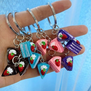 Creative mini strawberry layer cake keychains in chocolate, blue, pink, and purple colors