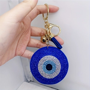 Detail view of the large blue evil eye charm with crystal rhinestones and blue tassel fringe