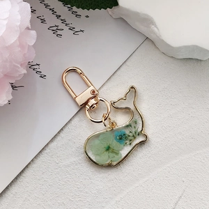 Kreativer Delphin-Anhänger aus Harz mit blauen Trockenblumen und goldenem Metallrahmen