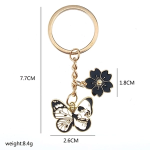 Detail of creative cherry blossom and skull butterfly pendant keychain in gold plating