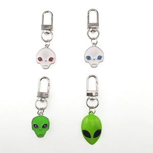 Dettaglio di quattro ciondoli alieni inclusi modelli UFO in smalto verde con ganci