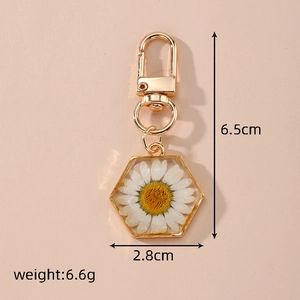 Hexagon gold keychain with dried white daisy flower in clear resin and size specs