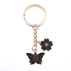 Golden keychain featuring enamel cherry blossom and crescent moon butterfly charms
