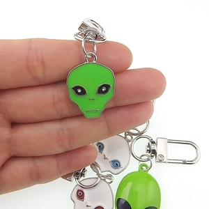 Portachiavi alieno UFO in lega verde e bianco con finitura smaltata sulla mano