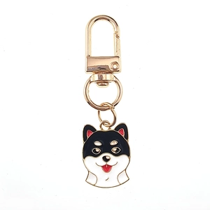 Détail d'un porte-clés émaillé Shiba Inu noir avec fermoir mousqueton doré sur fond blanc