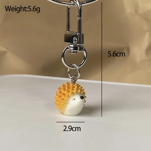 Detailed view of hedgehog resin charm with silver lobster clasp and size dimensions