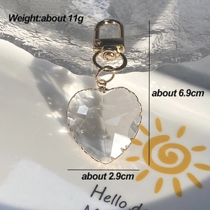 Detail view of heart-shaped crystal keychain with golden metal clasp and dimensions