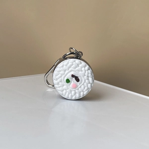 Détail d'une breloque boule de riz sushi 3D avec texture de grain et fermoir mousqueton argent