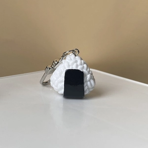 Vue détaillée d'un porte-clés onigiri 3D en résine avec texture de riz réaliste