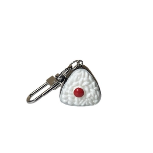 Porte-clés onigiri 3D réaliste avec prune rouge et algue noire sur un fond blanc neutre