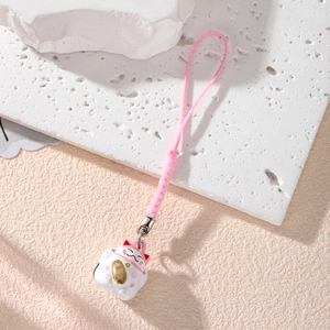 Cute Maneki Neko lucky cat phone charm with pink woven strap on a stone base