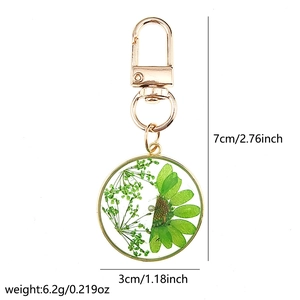 Macro detail of a resin keychain with green daisy flower petals and rose gold metal clasp