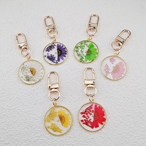 Preserved dried flower resin keychains in various colors with golden metal ring and lobster clasp