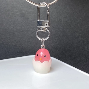 Close-up of cute pink resin chick keychain with white eggshell and metal clasp