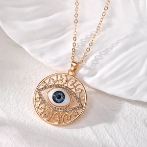 Vue détaillée du pendentif vintage œil bleu avec des strass brillants et des motifs dorés