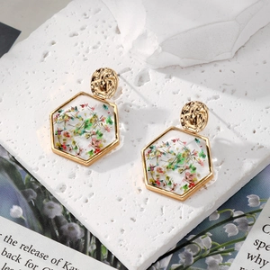 Golden hexagon earrings with colorful dried flowers and hammered metal stud design