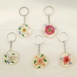 Set mit fünf handgefertigten Harz Schlüsselanhängern mit echten Trockenblumen und Schmetterling