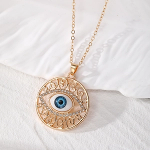 Vue détaillée du pendentif œil maléfique doré avec filigrane et strass brillants
