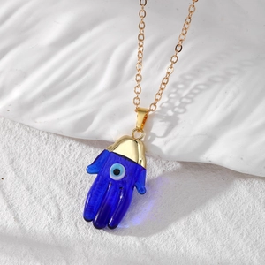 Boho Hamsa Hand necklace with blue glass evil eye pendant on a thin gold chain