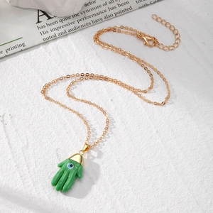 Ethnic Hamsa Hand necklace with green resin pendant and evil eye symbol on gold chain