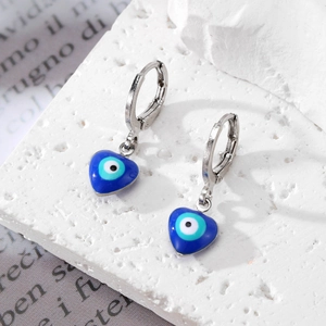 Mini cerchi a cuore in argento con ciondoli occhio blu smaltato su base di marmo bianco