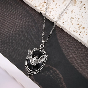 Détail du pendentif chauve-souris gothique avec pierre noire ovale et ailes argentées