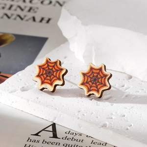 Detailed view of Halloween spider web wooden stud earrings on decorative stone
