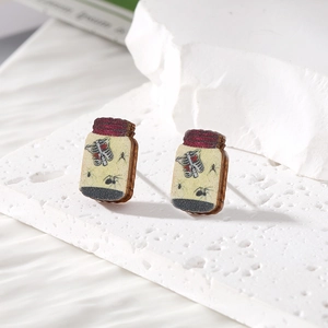 Detail of potion bottle wooden earrings with moth and spider specimen prints on stone base