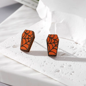 Detail of coffin-shaped wooden Halloween earrings featuring orange spider web patterns