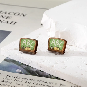 Boucles d'oreilles en bois en forme de tableau avec motif ABC sur fond blanc texturé