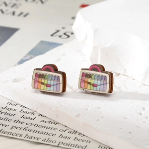 Gros plan de boucles d'oreilles créatives en bois en forme de sac aux rayures arc-en-ciel