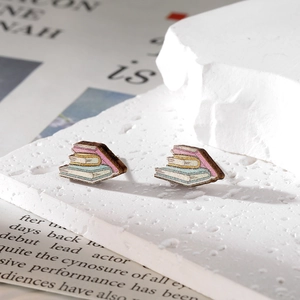 Boucles d'oreilles créatives en bois en forme de livres sur un socle en pierre blanche