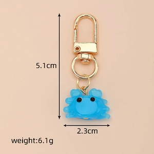 Vue détaillée d'un porte-clés crabe en verre bleu montrant les dimensions 5,1cm x 2,3cm et 6,1g