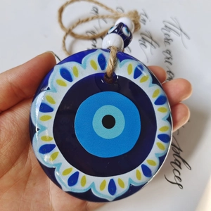 Detailed view of large acrylic evil eye hanging ornament with tribal print and blue beads