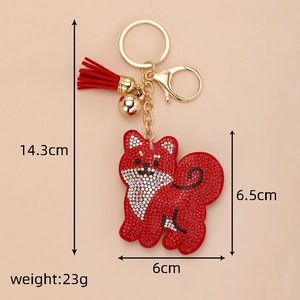 Détail du porte-clés chien en strass avec pompon rouge, clochette et dimensions