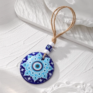 Detailed close-up of large blue acrylic Evil Eye pendant with mandala pattern and hemp rope