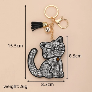 Détail du porte-clés chat avec strass brillants, pompon noir et clochette dorée